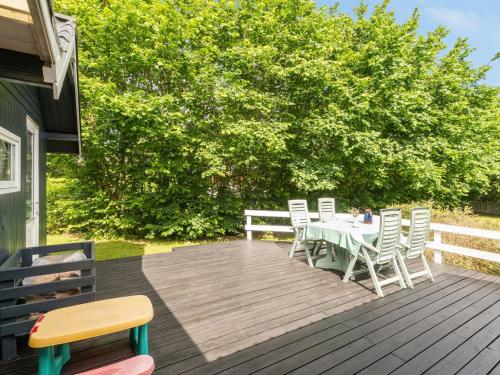 a wooden deck with a table and chairs on it at Holiday Home Nikoline - 150m to the fjord by Interhome in Roslev