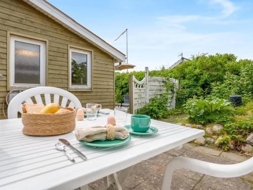 a white table with a basket of food on it at Holiday Home Eilke - 50m from the sea by Interhome in Rønde