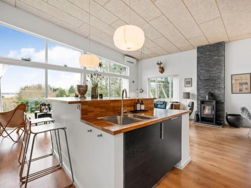 a kitchen with a sink and a living room at Holiday Home Tenna - 250m to the fjord by Interhome in Højslev