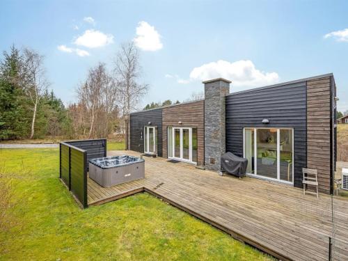 a house with a hot tub on a wooden deck at Holiday Home Tenna - 250m to the fjord by Interhome in Højslev