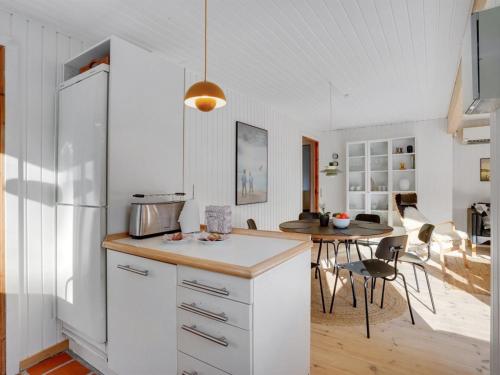 a kitchen with a white refrigerator and a table at Holiday Home Skjold - 600m from the sea by Interhome in Grenå