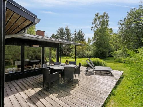 a wooden deck with a table and chairs on it at Holiday Home Skjold - 600m from the sea by Interhome in Grenå