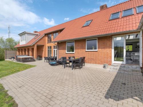 a brick house with a patio with tables and chairs at Holiday Home Markhild - 300m to the fjord by Interhome in Sønder Ydby