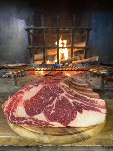 a large slab of meat in front of a fire at Dimora Del Ragno in Tivoli