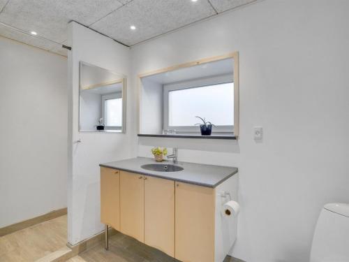 a bathroom with a sink and two windows at Holiday Home Markhild - 300m to the fjord by Interhome in Sønder Ydby