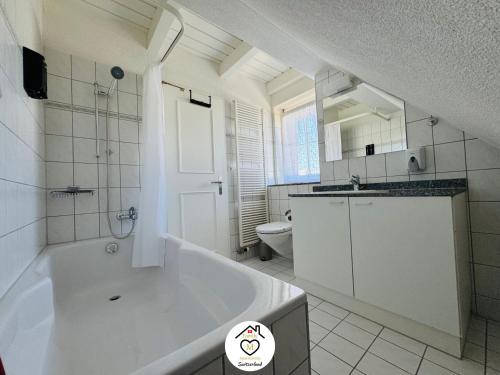 a large white bathroom with a tub and a toilet at Family M Apartments 40 - Luzern - Horw in Luzern