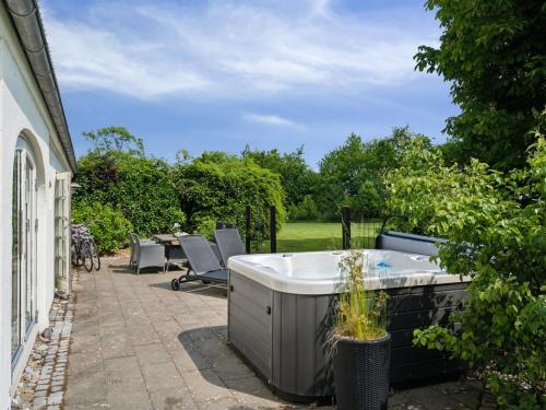 a hot tub on the patio of a house at Holiday Home Malinda - 500m from the sea by Interhome in Odder