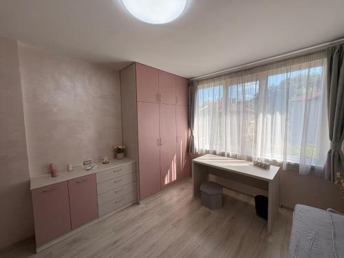 Kleines Zimmer mit einem Schreibtisch und einem Fenster in der Unterkunft В къщи in Weliko Tarnowo