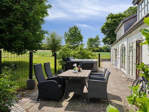 a patio with a wooden table and chairs at Holiday Home Malinda - 500m from the sea by Interhome in Odder