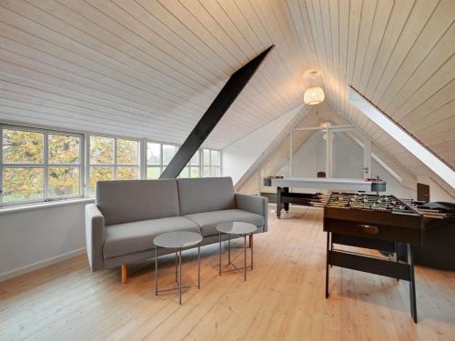 a living room with a couch and a piano at Holiday Home Malinda - 500m from the sea by Interhome in Odder