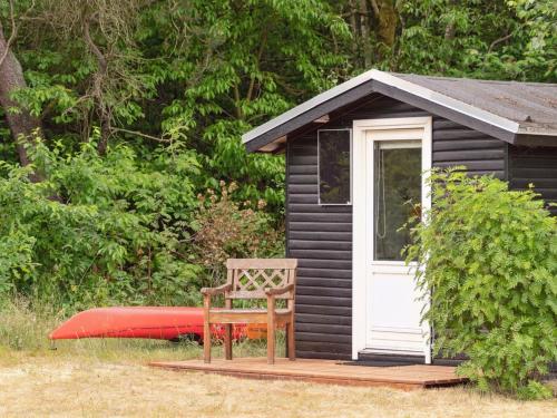 a bench and a house with a kayak next to it at Holiday Home Akke - 150m to the fjord by Interhome in Spottrup