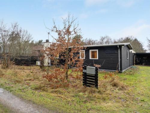 a small cabin in a field next to a road at Holiday Home Akke - 150m to the fjord by Interhome in Spottrup