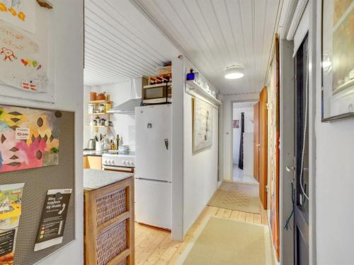 a kitchen with a white refrigerator and a hallway at Holiday Home Akke - 150m to the fjord by Interhome in Spottrup