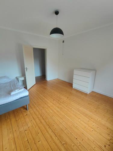 an empty room with a bed and a wooden floor at Katrineholm Longstay - Big 2 room apartment near the station in Katrineholm