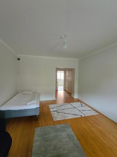 a white room with a bed and a wooden floor at Katrineholm Longstay - Big 2 room apartment near the station in Katrineholm