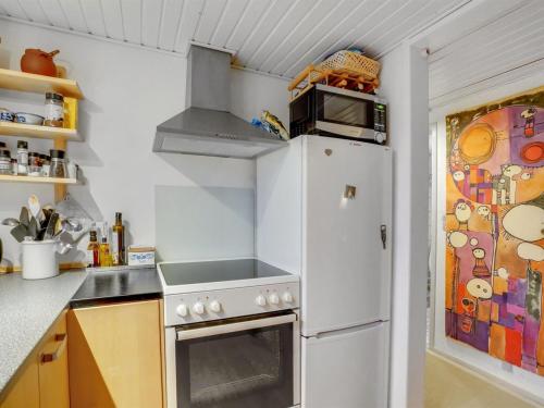 a kitchen with a white refrigerator and a microwave at Holiday Home Akke - 150m to the fjord by Interhome in Spottrup