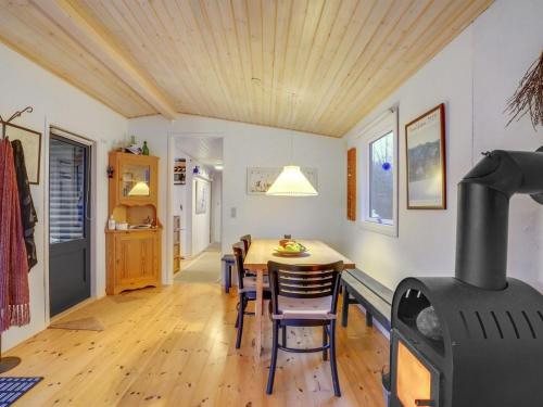 a dining room with a table and a wood stove at Holiday Home Akke - 150m to the fjord by Interhome in Spottrup
