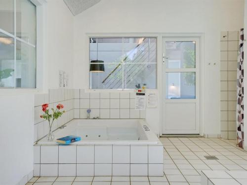 a white bathroom with a tub and a window at Holiday Home Aimy - 350m from the sea by Interhome in Grenå