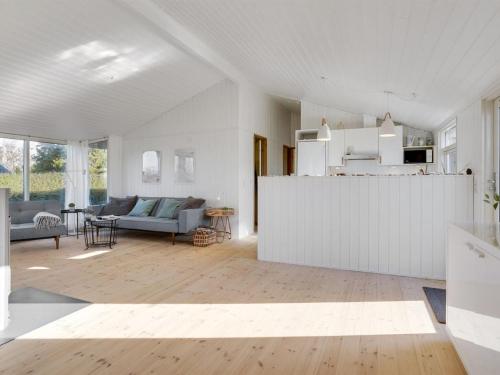 a white living room with a couch and a table at Holiday Home Evamaria - 350m from the sea by Interhome in Odder