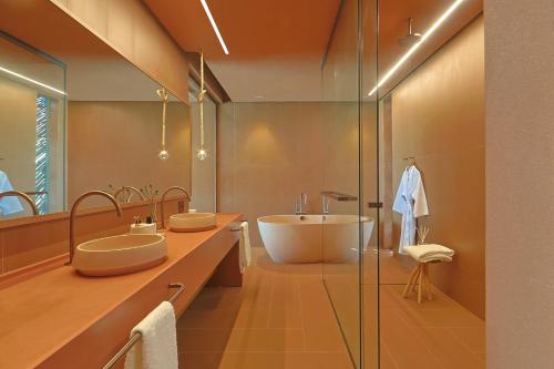 ポルト・デ・ペードラスにあるOrigem Patacho Design Hotelの洗面台2つとバスタブ付きのバスルーム
