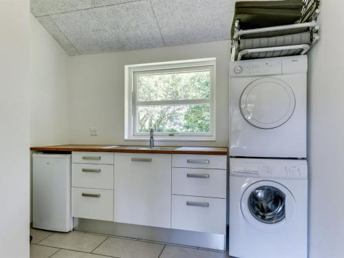 a kitchen with a washing machine and a window at Holiday Home Alrike - 850m from the sea by Interhome in Brøndstrup