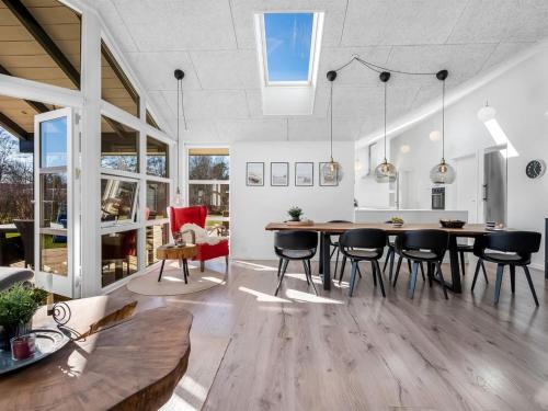 a dining room and living room with a table and chairs at Holiday Home Alrike - 850m from the sea by Interhome in Brøndstrup