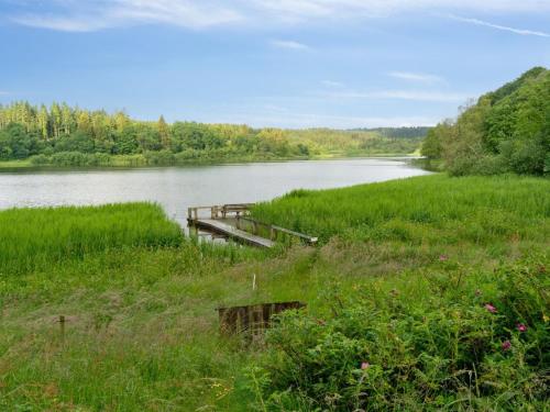 a wooden dock in the middle of a river at Holiday Home Gertje by Interhome in Bryrup