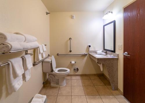a bathroom with a toilet and a sink and a mirror at Cobblestone Inn and Suites - Eaton in Eaton
