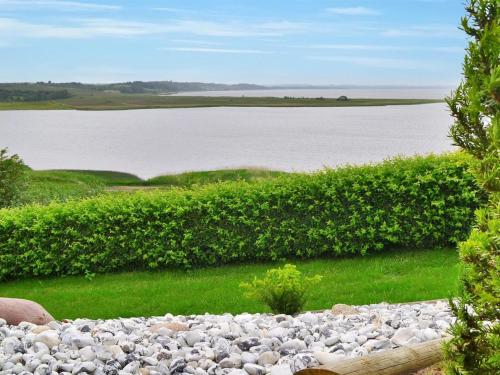 a large field of rocks next to a large body of water at Holiday Home Pirkka - 50m to the inlet by Interhome in Løgstrup