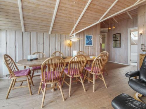 a dining room with a wooden table and chairs at Holiday Home Pirkka - 50m to the inlet by Interhome in Løgstrup