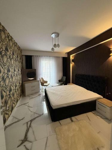 a bedroom with a bed and a desk in it at B&B Apartment Prishtina in Pristina