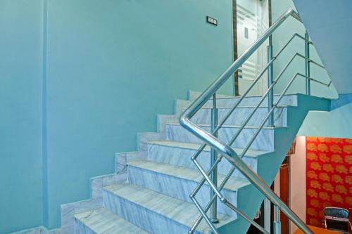 a stairway with blue walls and a metal railing at Hotel O Atharv Palace in Prayagraj