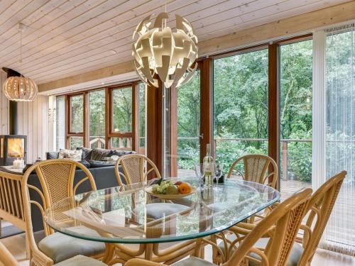 a dining room with a glass table and chairs at Holiday Home Nelie - 40km from the sea by Interhome in Silkeborg