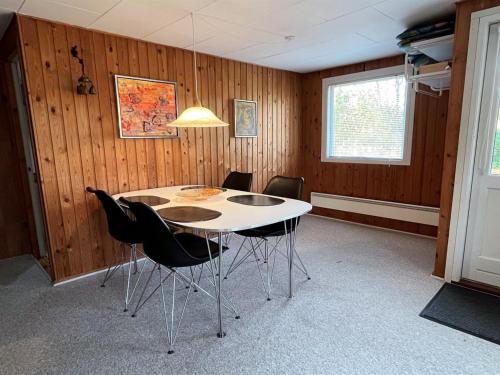 a dining room with a white table and chairs at Holiday Home Desche - 300m from the sea by Interhome in Ørsted