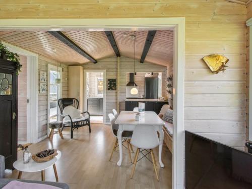 a dining room and living room with a table and chairs at Holiday Home Botwith - 400m from the sea by Interhome in Ørsted