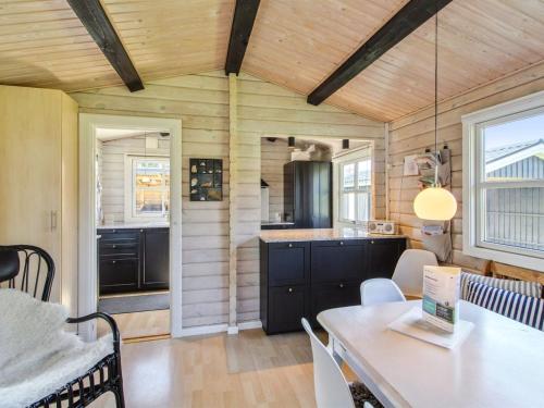a kitchen and dining room with a table and chairs at Holiday Home Botwith - 400m from the sea by Interhome in Ørsted