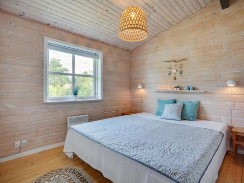 a bedroom with a bed and a window and a chandelier at Holiday Home Botwith - 400m from the sea by Interhome in Ørsted