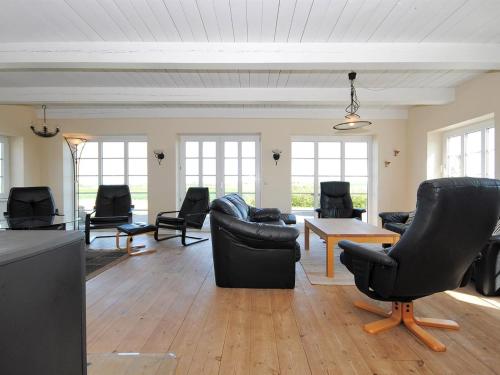 a living room with black chairs and a table at Holiday Home Alois - 1km to the fjord by Interhome in Hesselbjerg