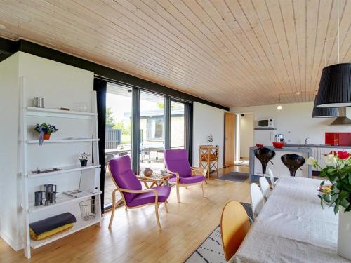 a living room with purple chairs and a table at Holiday Home Kiowa - 100m from the sea by Interhome in Allingåbro