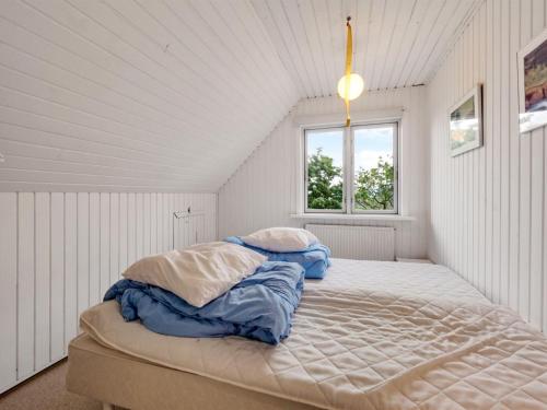 a bedroom with a large bed with blue sheets at Holiday Home Emmie - 50m to the fjord by Interhome in Skarum