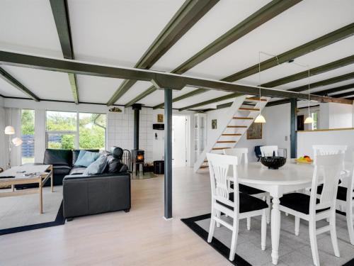 a living room and dining room with a white table at Holiday Home Edvia - 700m to the fjord by Interhome in Løgstrup