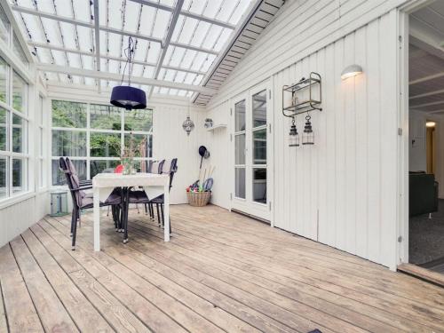 a screened in porch with a table and chairs at Holiday Home Gunward - 1-5km from the sea by Interhome in Sæby