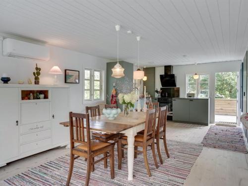 a kitchen and dining room with a wooden table and chairs at Holiday Home Jaana - 780m to the fjord by Interhome in Storvorde