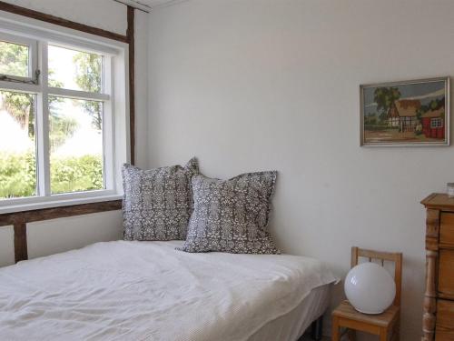 a bedroom with a bed with pillows and a window at Holiday Home Melina - 100m from the sea by Interhome in Malling