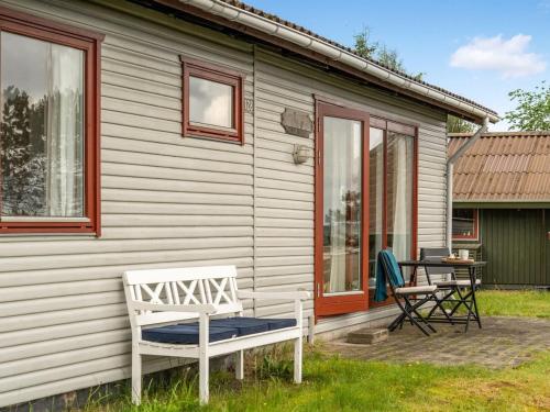 a white house with a bench and a table at Holiday Home Elpida - 100m from the sea by Interhome in Glesborg