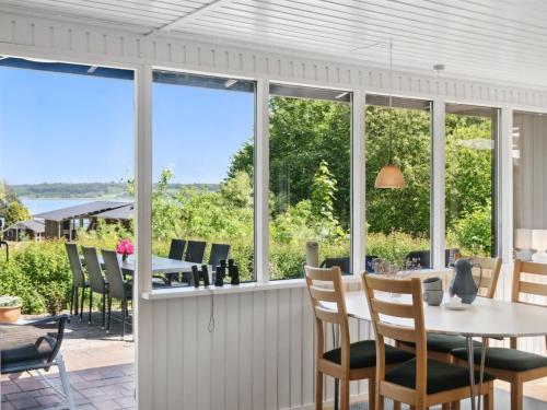 a screened in porch with a table and chairs at Holiday Home Self - 400m to the fjord by Interhome in Løgstrup