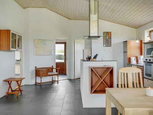 a kitchen with white walls and a table and a counter at Holiday Home Roope - 50m from the sea by Interhome in Storvorde
