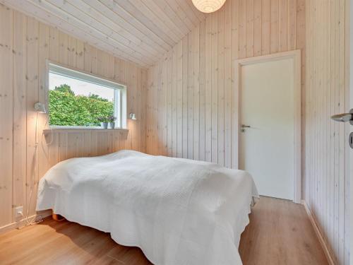 a bedroom with a white bed and a window at Holiday Home Regni - 300m to the inlet by Interhome in Nykøbing Mors