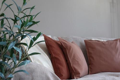 a group of pillows on a couch with a plant at Quayside Nest - Central Newcastle Apartment with Free Private Parking in Newcastle upon Tyne