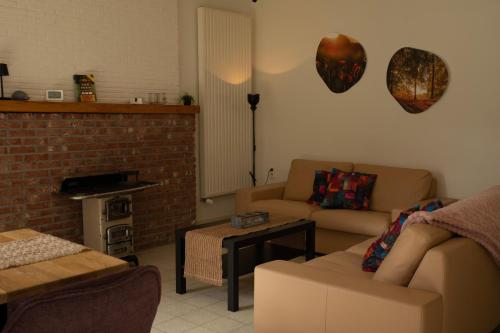 a living room with two couches and a fireplace at Tussen Heide en Bos in het Nationaal Park Hoge Kempen in Oudsbergen 